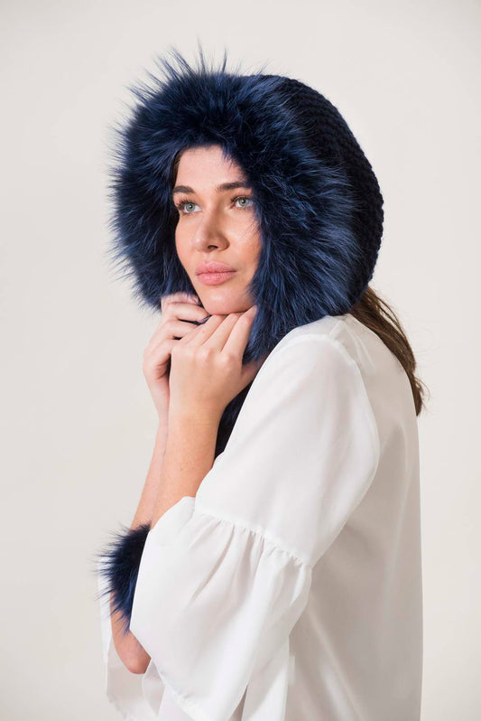 a model wearing a handmade blue knit hat with fur details
