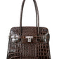 Brown crocodile skin handbag with silver hardware on a white background