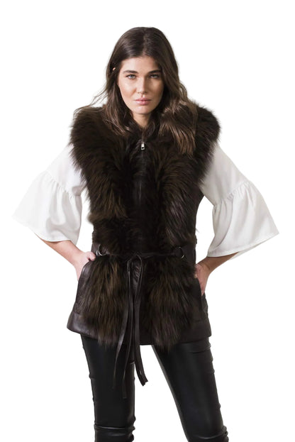 Woman wearing a dark fur vest over a white shirt on a plain background
