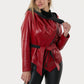 Woman wearing a red leather jacket and black pants on a white background