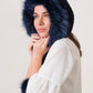 a model wearing a handmade blue knit hat with fur details